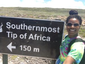 Michaela Tummings '17 next to a sign that says "Southernmost Tip of Africa"