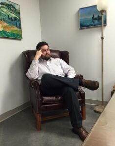 Jeffrey Zimmer '10 thinks while sitting in chair at work