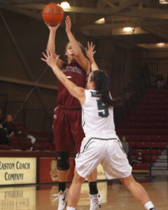 Women's basketball player Anna Ptasinski '18 shoots the basketball while being defended by a Loyola opponent.