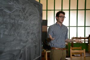 Will Gordon '17 stands at a blackboard as he teaches high school students in Madagascar through Lafayette Initiative for Malagasy Education.