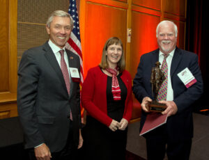 Board vice chair Steve Pryor '71 and President Alison Byerly present the Marquis statue to Kent Rockwell '66.