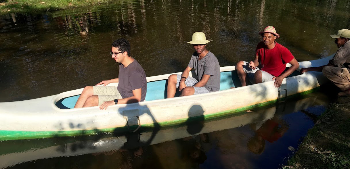 Three students ride in a canoe.